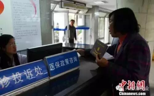 资料图。一名女子在医保政策咨询台前咨询。 王思哲 摄